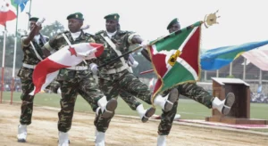 A group of soldiers from Burundi marching in a parade holding their flags