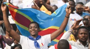 A young person holds up the flag of The Democratic Republic of Congo