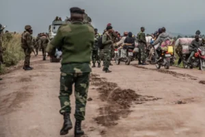 Soldiers man a road in Eastern DRC as motorists pass by