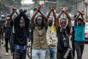 A group of youth in the streets of Nairobi with arms interlocked and raised in the air. The youth are protesting against bad governance.