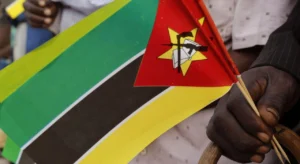 A hand holding a Mozambique hand flag